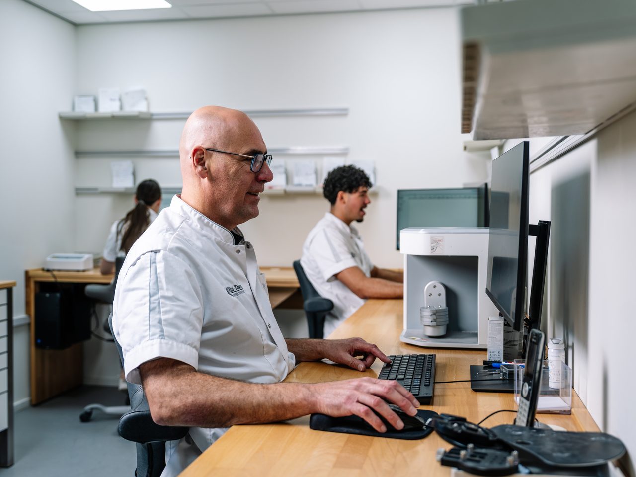 Tandtechnici werken aan de scanners in de digitale werkruimte
