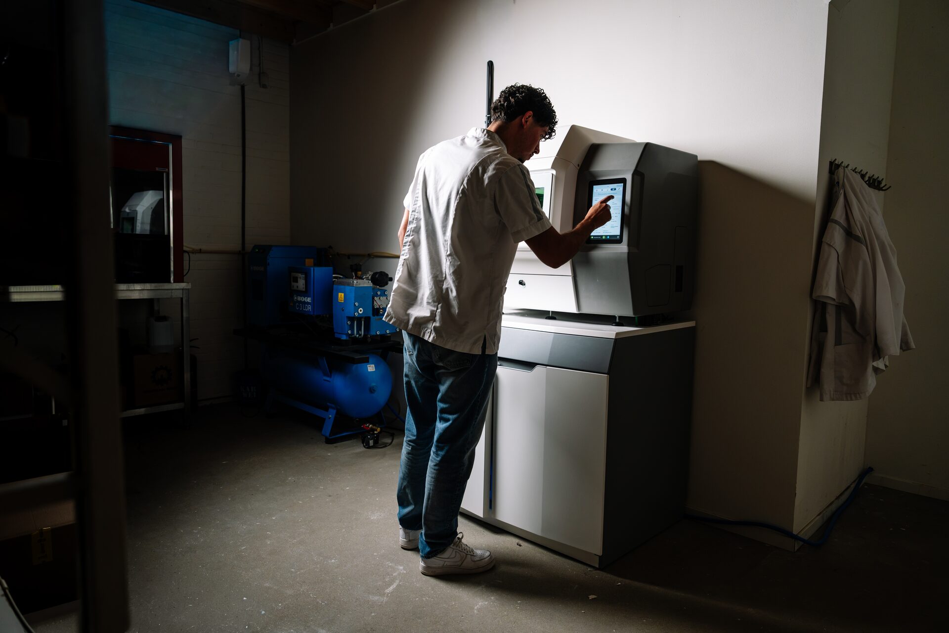 Tandtechnicus bedient de CAD/CAM-freesmachine in het laboratorium