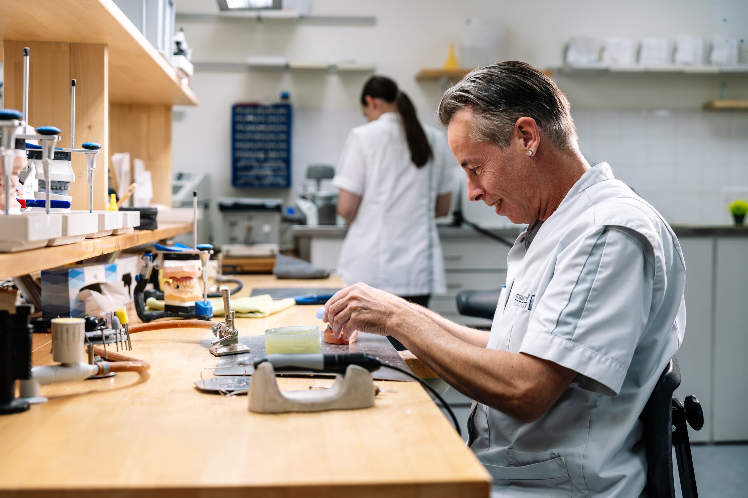 Tandtechnicus aan de werkbank in het laboratorium in Kerk-Avezaath, startpunt van de haal- en brengservice