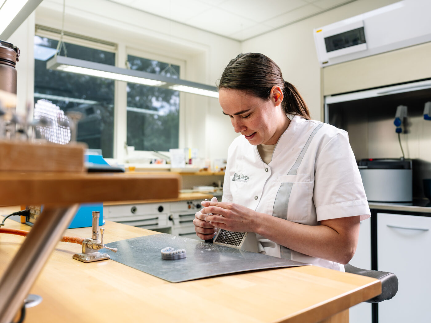 Tandtechnicus aan het werk in het laboratorium van Van Toorn Tandtechniek in Kerk-Avezaath